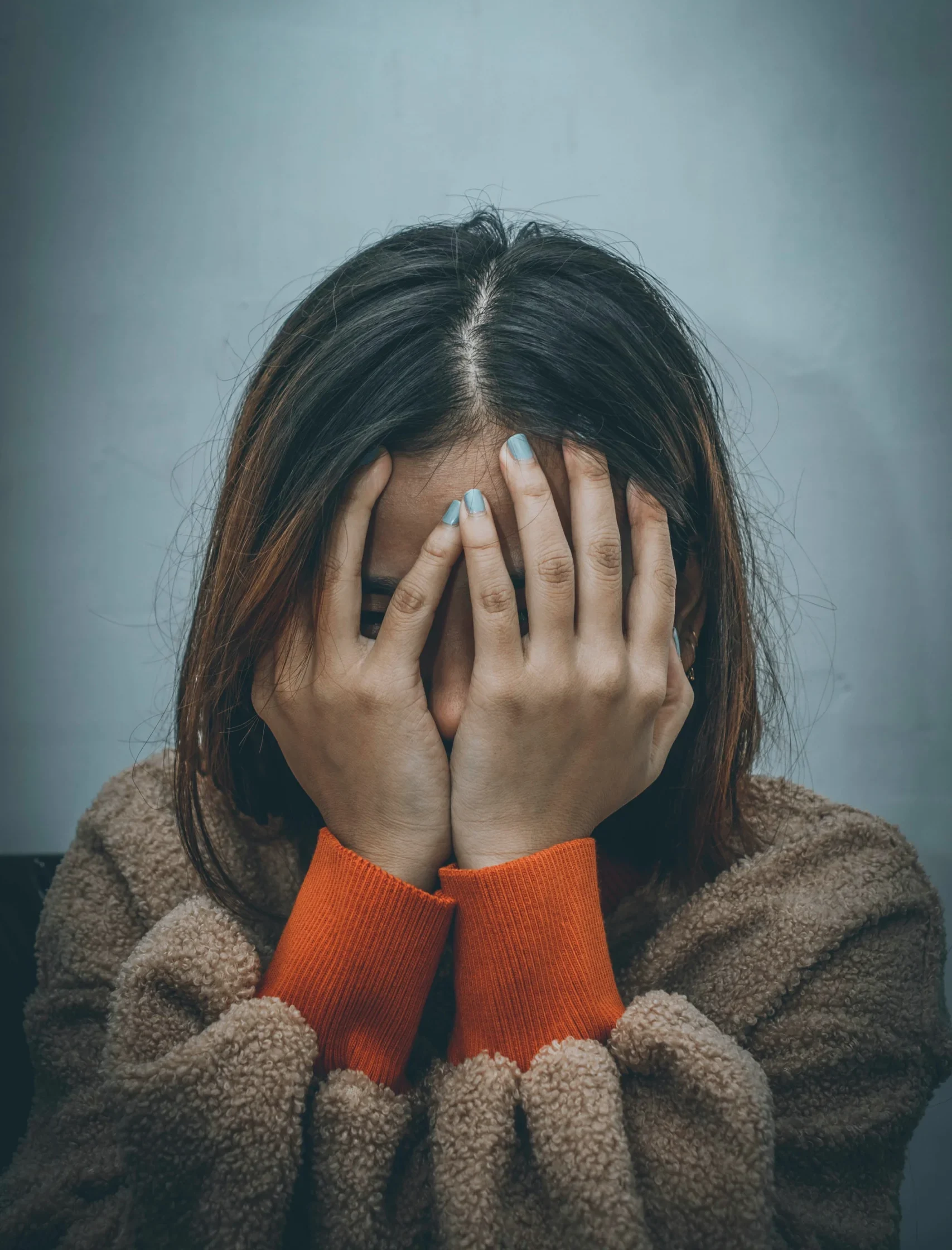девушка закрывает лицо руками