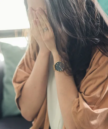 девушка закрывает лицо руками