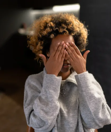 девушка закрывает лицо руками