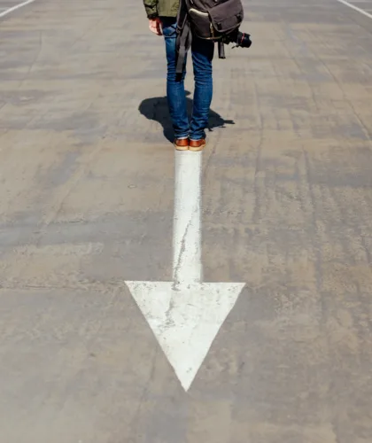 стрелка на асфальте и человек